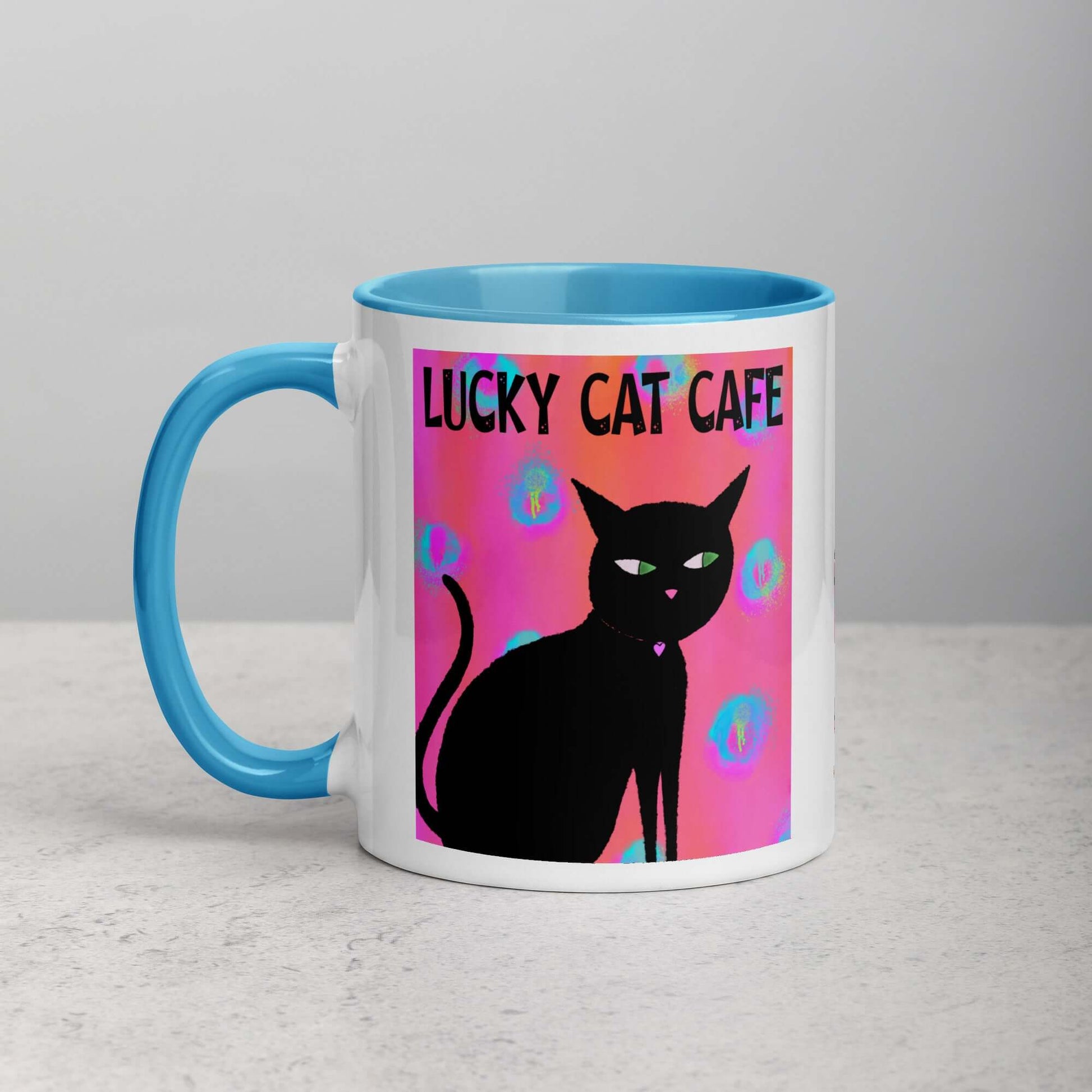 Black Cat on Hot Pink Tie Dye Background with Text “Lucky Cat Cafe” Mug with Light Blue Color Inside Left Handed Front View