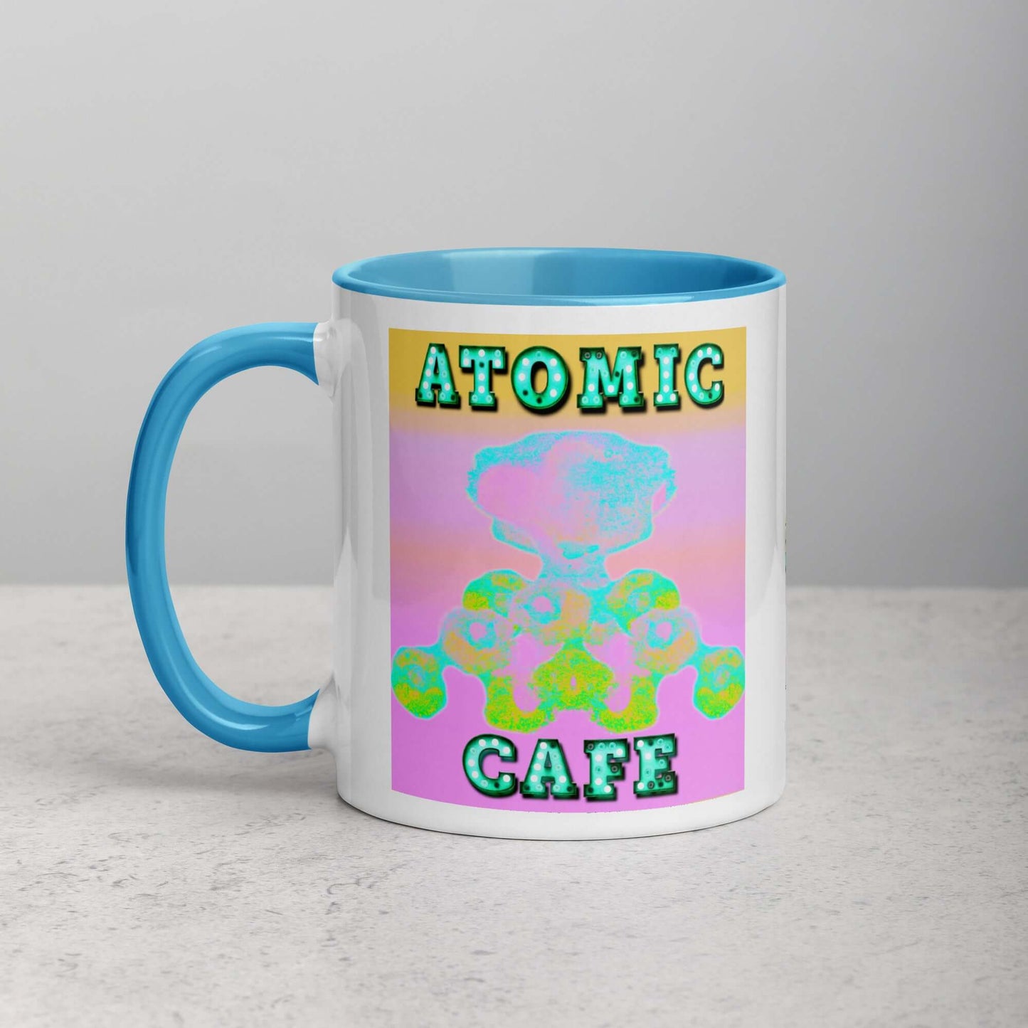 Pastel Atomic Blast with “Atomic Cafe” in Marquee Letters Mug with Light Blue Color Inside Left Handed Front View