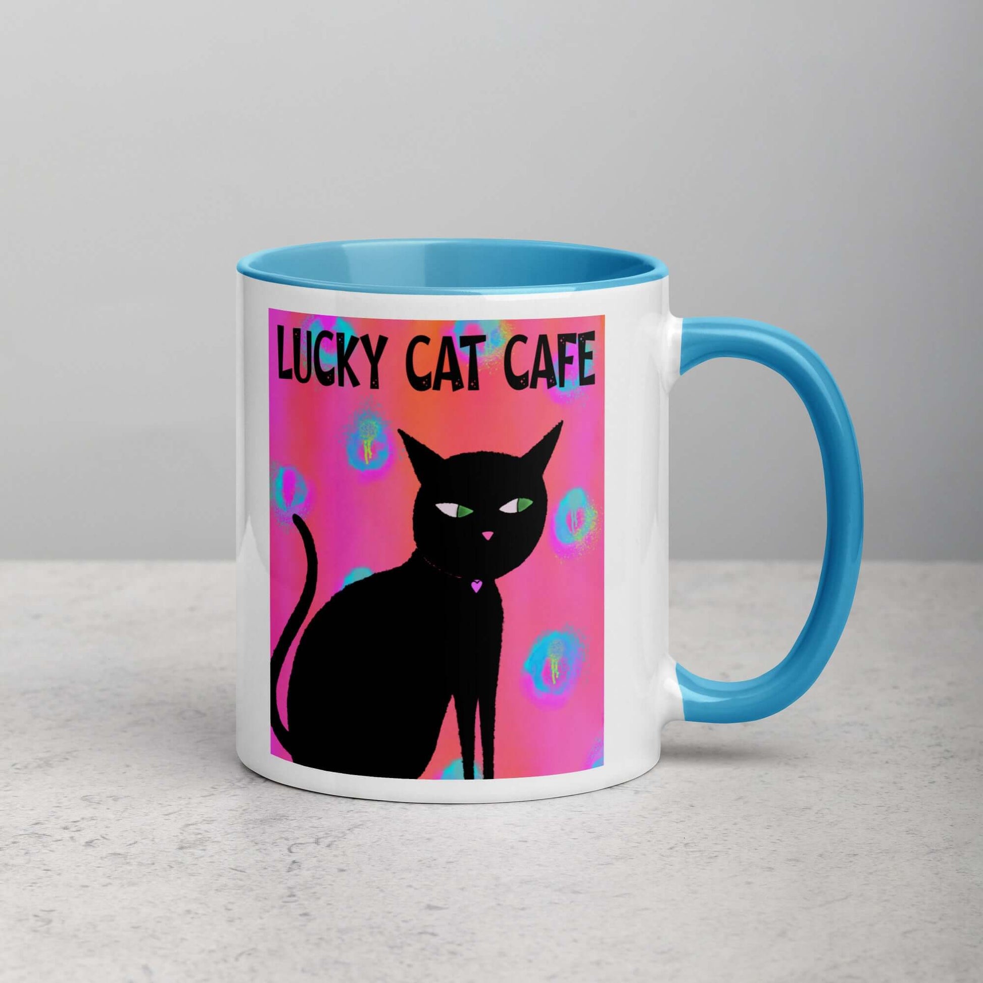 Black Cat on Hot Pink Tie Dye Background with Text “Lucky Cat Cafe” Mug with Light Blue Color Inside Right Handed Front View