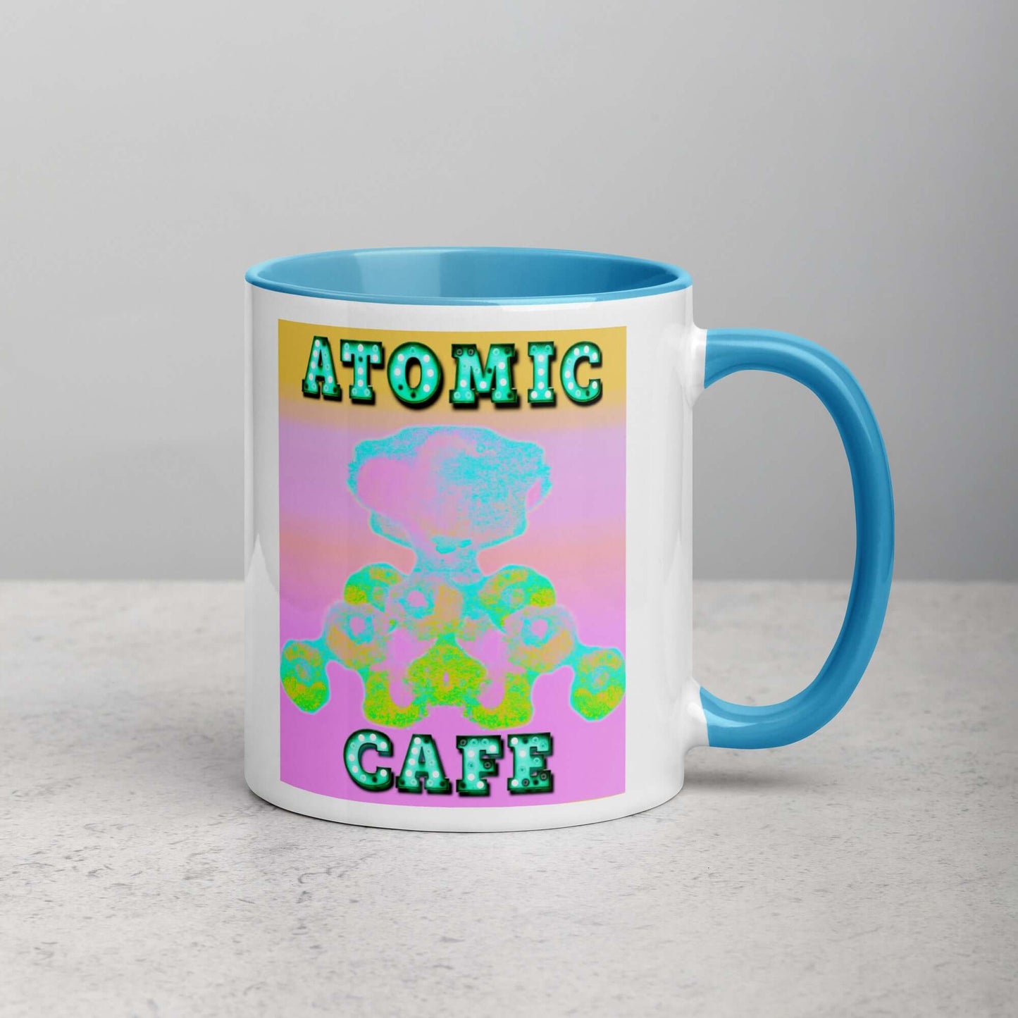 Pastel Atomic Blast with “Atomic Cafe” in Marquee Letters Mug with Light Blue Color Inside Right Handed Front View