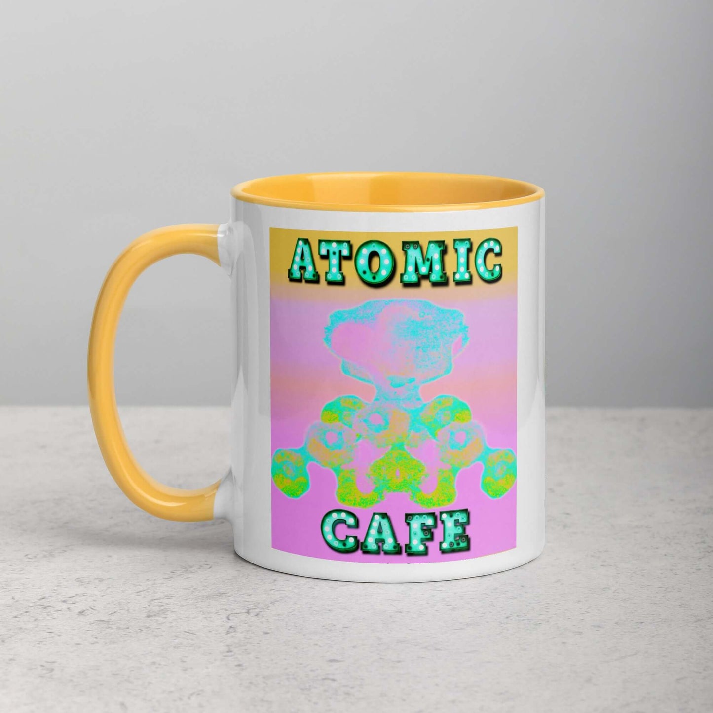 Pastel Atomic Blast with “Atomic Cafe” in Marquee Letters Mug with Golden Yellow Color Inside Left Handed Front View 
