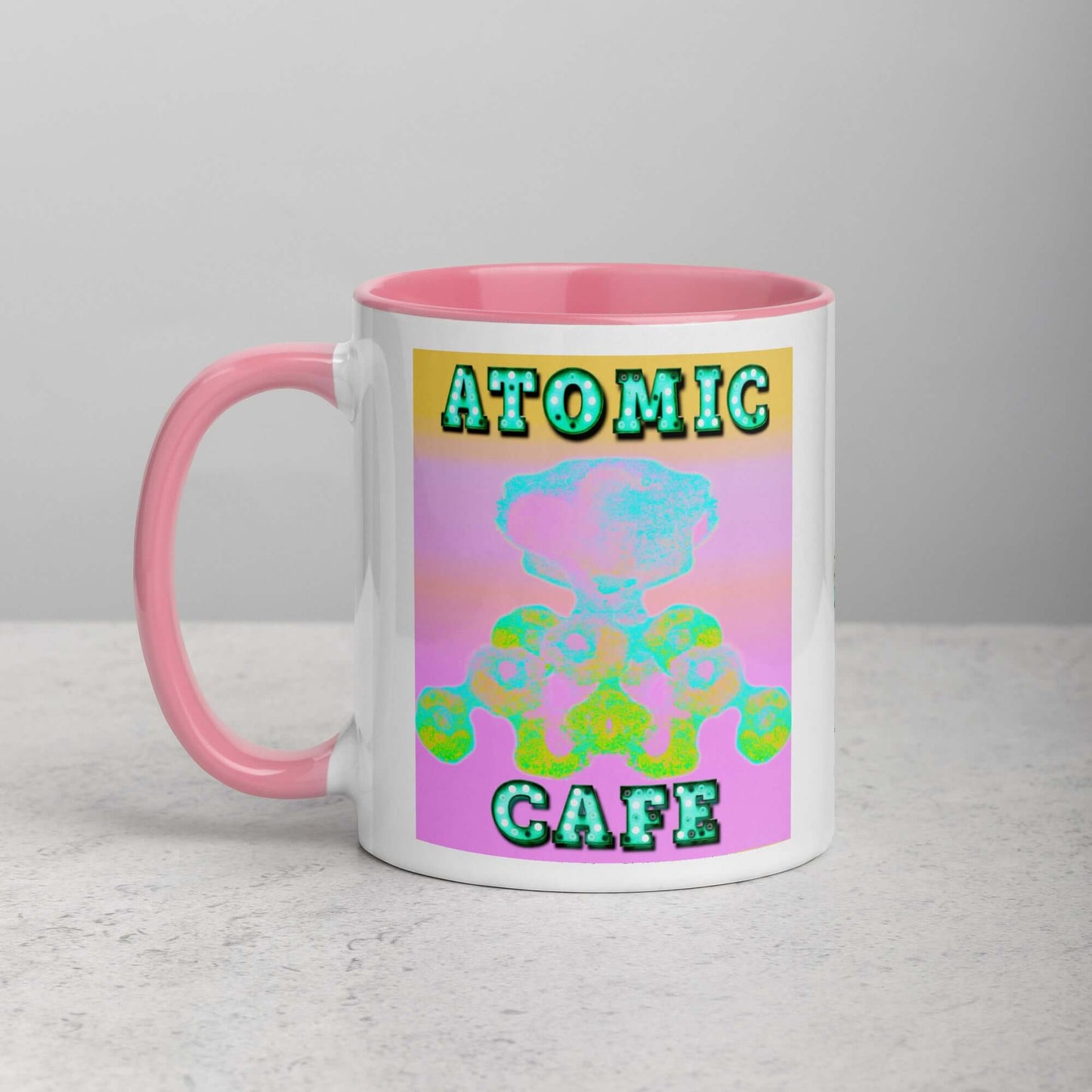 Pastel Atomic Blast with “Atomic Cafe” in Marquee Letters Mug with Light Pink Color Inside Left Handed Front View