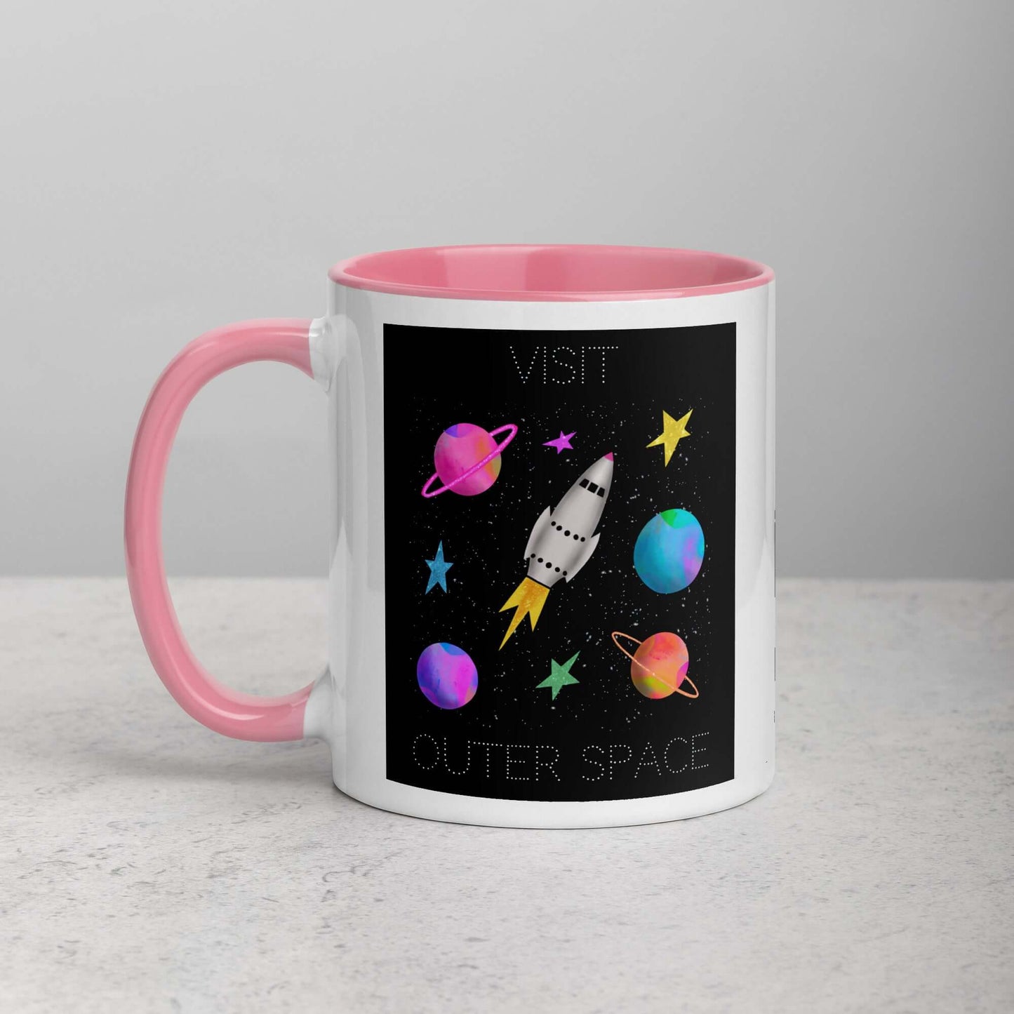 Whimsical Space Rocket with Colorful Planets and Stars on Black Background with Text “Visit Outer Space” Mug with Light Pink Color Inside Left Handed Front View