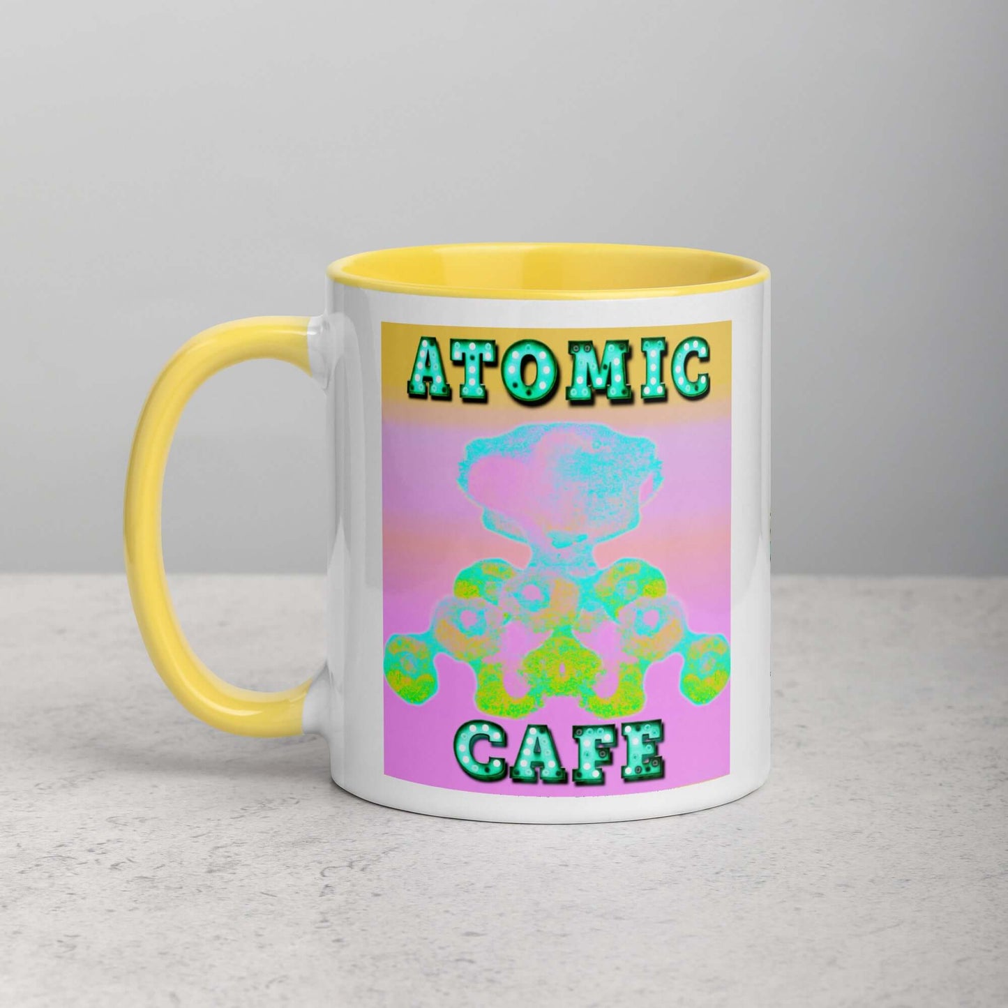 Pastel Atomic Blast with “Atomic Cafe” in Marquee Letters Mug with Bright Yellow Color Inside Left Handed Front View 